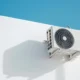 Una persona limpia un aparato de aire acondicionado en casa para ilustrar How to clean and disinfect your air conditioner at home.